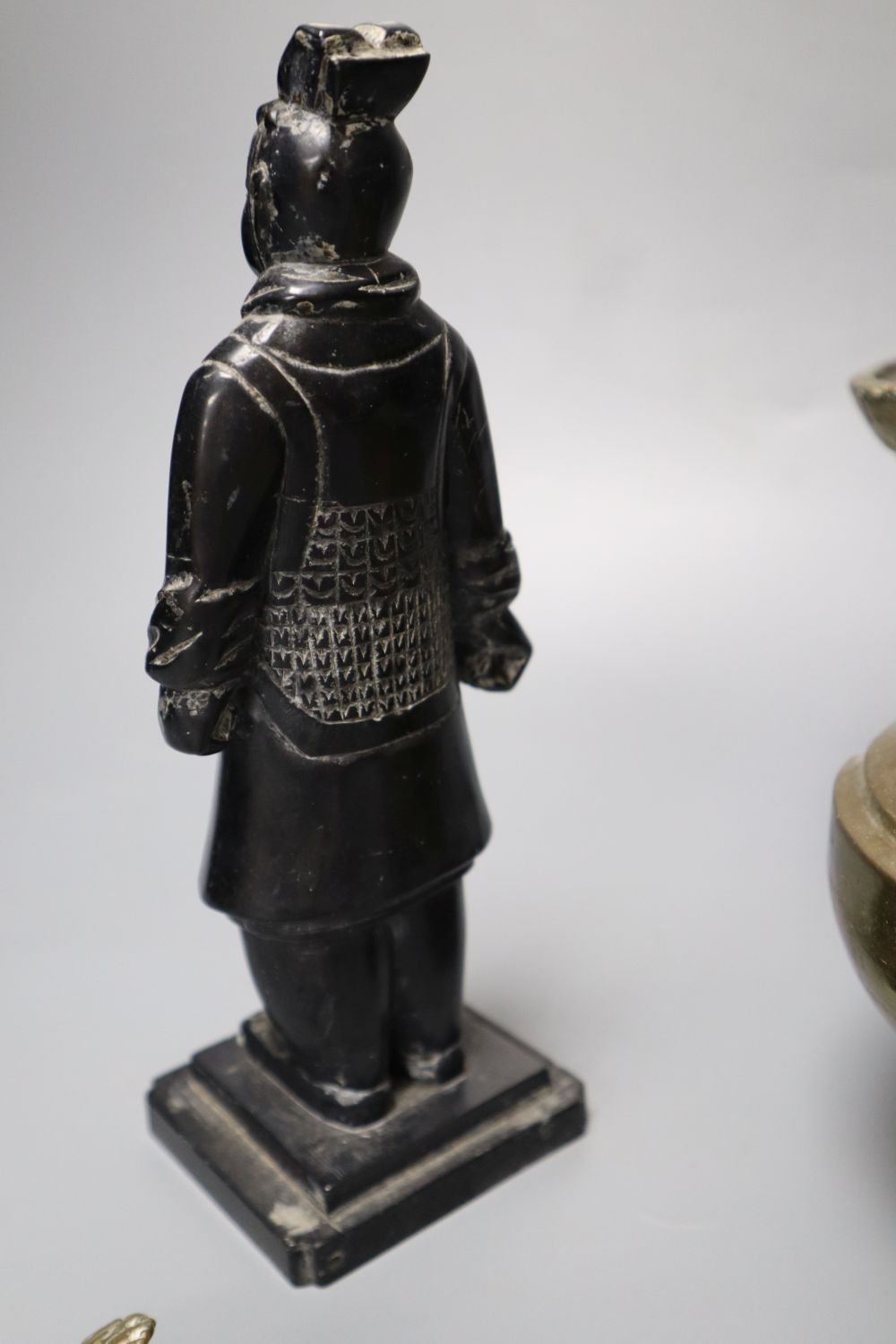 A Himalayan Buddhist brass lamp/ewer with related ladle, 26cm, 19th/20th century and a carved black mineral Chinese stone figure